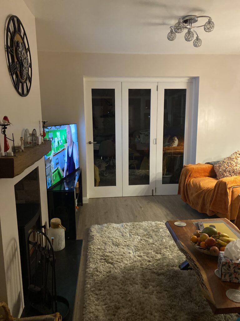 A customer image of a closed white bifold door in a living room.